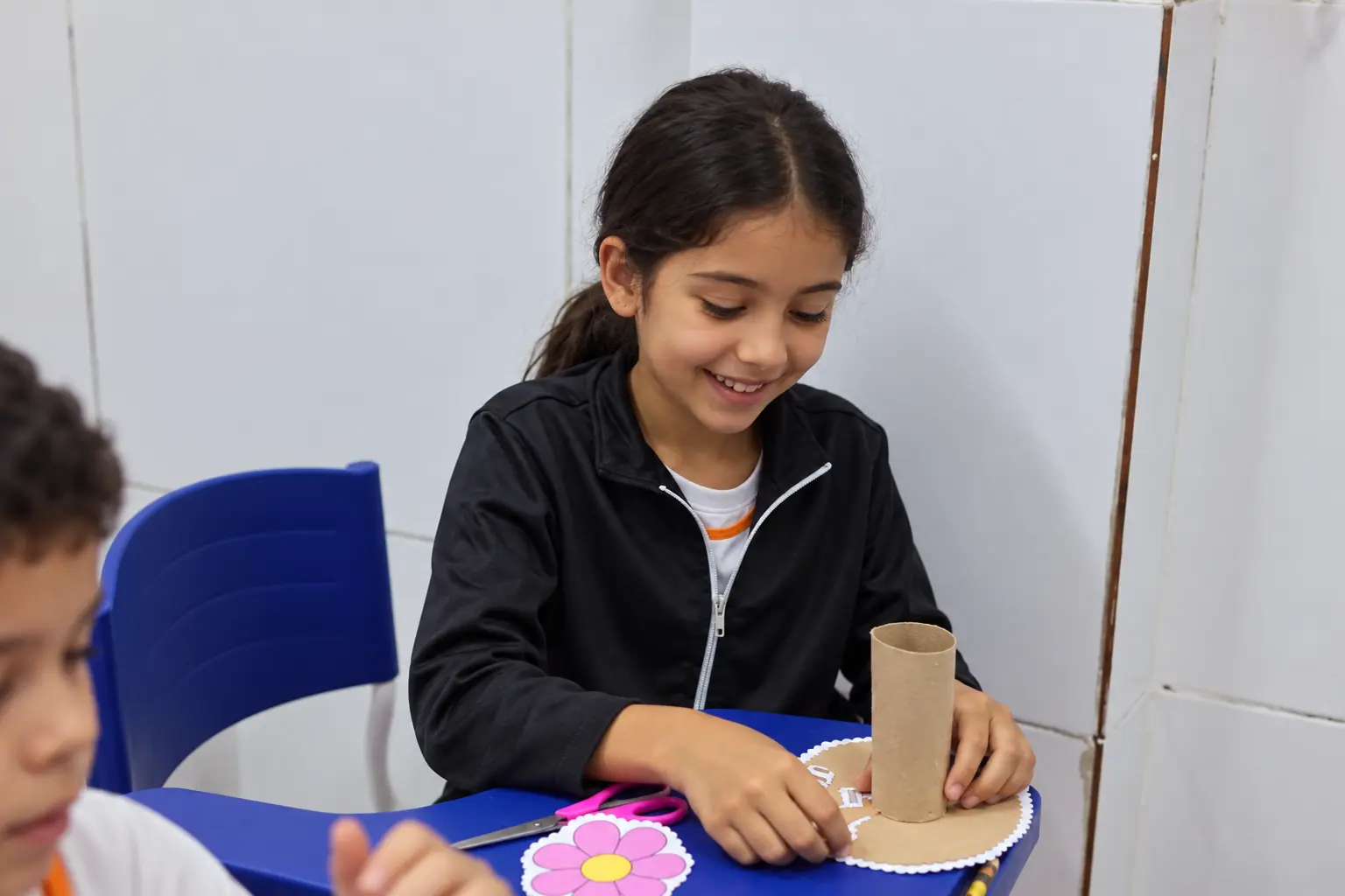 Aluna montando um trabalho de artes com rolo de papelão